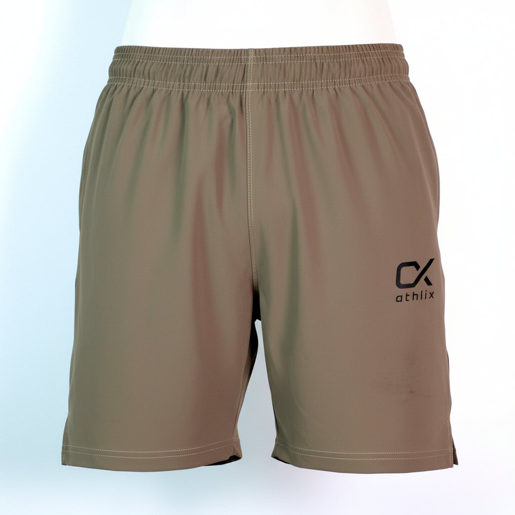 A close-up of a person wearing brown athletic shorts with an elastic waistband and a black and gold 'athlix' logo on the left leg, paired with a light blue t-shirt.